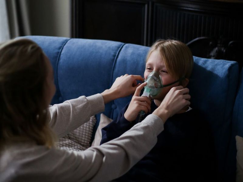 A parent helping a child with a nebulizer