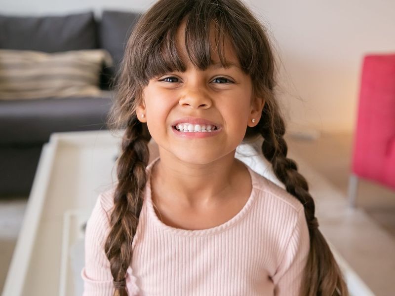 A smiling girl with small stud earrings